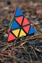 May 30, 2022, New York, USA: Triangular Rubik\'s Cube in the shape of a pyramid lies on brown pine needles in nature