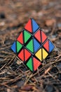 May 30, 2022, New York, USA: Triangular Rubik\'s Cube in the shape of a pyramid lies on brown pine needles in nature