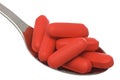 May red pills in small spoon Royalty Free Stock Photo