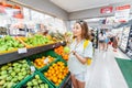 young woman choosing apples in supermarket, fruits department