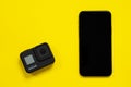 May 08, 2020, Rostov, Russia: Action camera GoPro Hero 8 Black and mobile phone Apple iPhone 11 Pro, lying on bright yellow