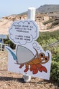 A sign showing a cartoon crab tells visitors not to steal wildlife from tide pools at the