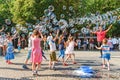 street artist makes a soap bubble show for children to receive donations from their parents