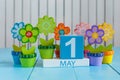 May 1st. Image of may 1 wooden color calendar on white background with flowers. Spring day, empty space for text