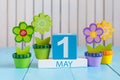 May 1st. Image of may 1 wooden color calendar on white background with flowers. Spring day, empty space for text