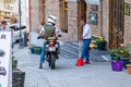 A young European on a motorcycle talking with an African-American friend.