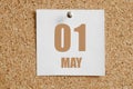 May 01. 01th day of the month, calendar date. White calendar sheet attached to brown cork board.Spring month, day of the year