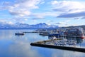 May 28 2022 - Tromso, Norway: Ships approach the port, Snowy mountains in the background