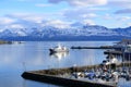 May 28 2022 - Tromso, Norway: Ships approach the port, Snowy mountains in the background Royalty Free Stock Photo