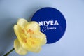 May 1, 2022 Ukraine city Kyiv jar of Nivea beauty product cream, narcissus flower a colored background