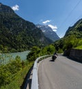 Motorcycle rider enjoys a ride on the curving mountain roads in the idyllic Swiss Alps