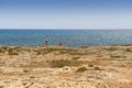 May 2, 2014: Young couple walks and takes photos on a rocky beach. Cyprus