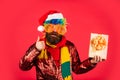 May your Christmas be filled with joyful noise. merry christmas. man with beard on red background. brutal bearded man in Royalty Free Stock Photo