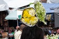 A Mayan woman is carrying on her head bouquets of flowers at the Chichicastenango market in Guatemala. Royalty Free Stock Photo