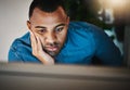 Maybe the escape key will get me outta here. a young businessman looking bored while working during a late night in a Royalty Free Stock Photo