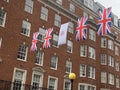 Rainy day in Mayfair in London with coronation flags and British flags in May 2023