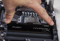 Man installs an DDR 4 DIMM 16 Gb Kingston HyperX Fury Memory RAM Module in the slot on the motherboard closeup Royalty Free Stock Photo