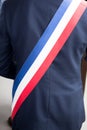 Mayor of French town with French tricolour flag mayoral sash