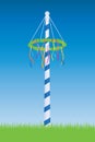 maypole with colorful ribbons on blue sky background