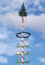 Maypole with craft guild marks, blue and white sky Royalty Free Stock Photo