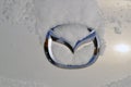 Mazda car logo on the trunk lid under a layer of snow Royalty Free Stock Photo