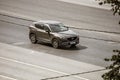 Mazda CX-5 2.5 L Skyactiv-G car on the highway road in motion. Aerial front side view of brown SUV