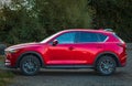 Mazda CX-5 Redesigned Crossover SUV. Driving countryside in forest. Side view