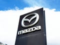 Mazda logo sign on tall black structure with blue sky background Royalty Free Stock Photo