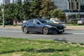 Mazda 6 rushes along the street in city with blurred background. Front side view rolling shot with Mazda6 third generation in