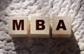 MBA master of business administration concept. Abbreviation inscription on wooden cubes standing on on a crochet carpet Royalty Free Stock Photo