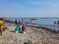 MBour, Senegal- April 25 2019: Unidentified Senegalese men and women waiting for the fishermen at the fish market in the port city Royalty Free Stock Photo