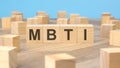 MBTI - word is written on wooden cubes close-up. bright blue background, financial business concept