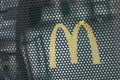 Mc Donald`s logo on metallic fence at the fast food entry in the street