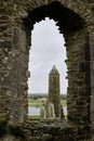 McCarthy's Tower seen through a cathedral window in the medieval monastery of Clonmacnoise, during a rainy summer day