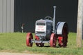 A McCORMICK DEERING Antique Tractor in a farm yard with green grass