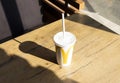 McDonald Drink Milkshake In Big White Cup With Logo, Paper Straw on Table In Restaurant