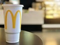 Mcdonald`s coca cola cup big size on the table in Mcdonald`s restaurant with blurry backgroun