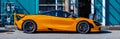 McLaren 720S supercar parked on a street. Orange supercar on the street of a city