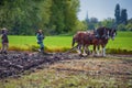 Two women guide a plow pulled by draft horses Royalty Free Stock Photo