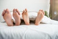 Man and woman barefeet lying in the bed