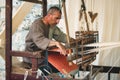 MDINA / MALTA - MAY 04 2019: Man with a foot-treadle floor loom to weave cloth