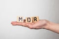 MDR Medical Device Regulation. Wooden letters in a woman& x27;s hand