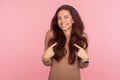 This is me, I am awesome! Portrait of happy young woman with brunette wavy hair pointing herself and smiling excitedly