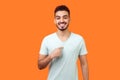 This is me! Portrait of glad satisfied brunette man pointing at himself. indoor studio shot isolated on orange background Royalty Free Stock Photo