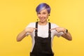 This is me! Portrait of joyful hipster woman pointing herself, smiling and expressing pride. yellow background studio shot