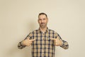 This is me. Portrait of man in plaid shirt pointing at himself and looking with arrogant and selfish expression, feeling Royalty Free Stock Photo