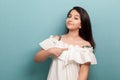 This is me. Portrait of proud beautiful brunette young girl with black straight hair in white dress standing, pointing herself and