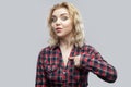 Is it me? Portrait of surprised beautiful blonde young woman in casual red checkered shirt standing, pointing herself with amazed Royalty Free Stock Photo