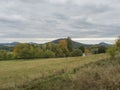 Meadow with autumn colorful forest, trees and hills and country rustic house, moody sky. Landscape in Luzicke hory Royalty Free Stock Photo