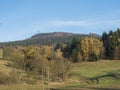 Meadow with autumn colorful forest and trees and hills with lookout tower and blue sky landscape in luzicke hory Royalty Free Stock Photo